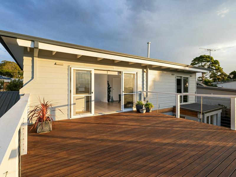 Wooden deck beside a white house